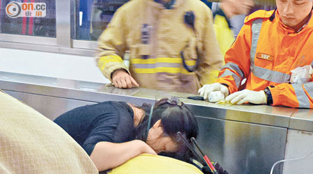 消防員拯救被扶手梯夾趾的婦人。（黃子源攝）