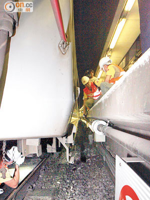 旺角東站<br>港鐵工程人員爬入肇事列車車底檢查。（林少兒攝）