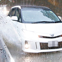 灣仔堅尼地道水浸，車輛行駛時濺起水花。