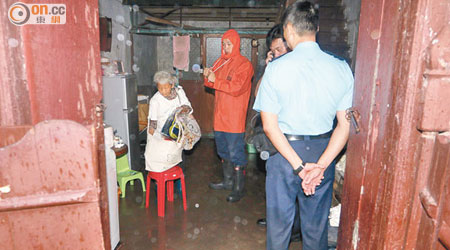 老婦指暴雨下屋內水浸。（伍啓衛攝）