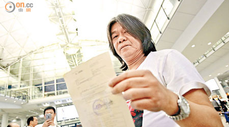 梁國雄返回香港後，展示馬來西亞當局拒絕他入境的文件。（黃仲民攝）