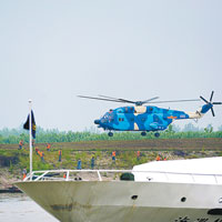 直升機協助搜救船拯救生還者。（中新社圖片）