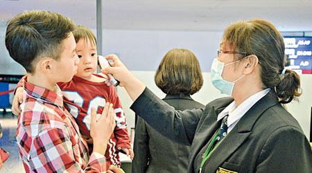 台北桃園機場加強旅客檢疫措施，檢測體溫。（中央社圖片）