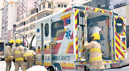 救護車行駛中冒煙，消防員協助抬出車上的病人。（讀者提供）