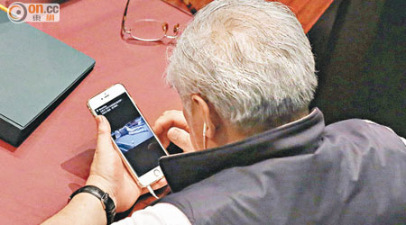 議員黃定光在政改辯論期間，公然透過手機觀看美女短片。（黃永俊攝）