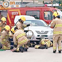 消防員正拯救被困車底傷者。