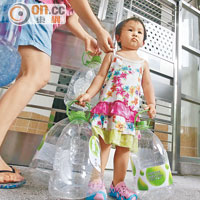 小童帶備多個大容量膠水樽往取食水。（黃永俊攝）