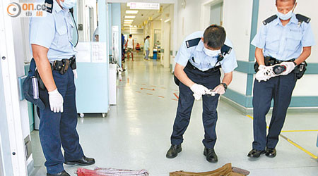 警員替死者染血衣物拍照搜證。（梁卓明攝）
