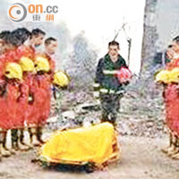 消防員為遇難同袍致哀。