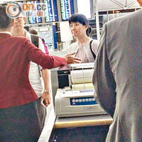 受影響乘客在登機閘口前與職員了解事件。