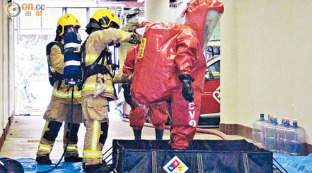 有消防員穿起保護衣處理化學品。