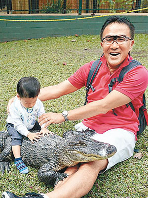 田北辰帶孫仔坐鱷魚背，認真夠膽識。（互聯網圖片）