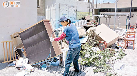 記者目擊有裝修工人以手推車運送家居廢物在垃圾站外棄置。