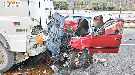 的士與泥頭車相撞，的士車頭嚴重損毀。（文健雄攝）