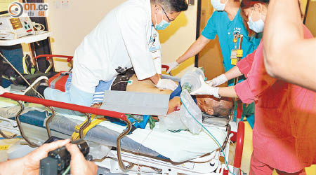墮海行山客送院時，醫生跪在床上進行搶救。（陳浩然攝）