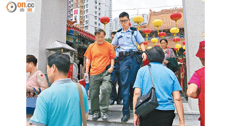 警員在黃大仙祠帶走一名男子。（張世洋攝）