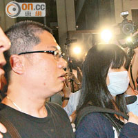本土派人士梁金成（左）與疑似「粉筆少女」（中）被警員帶走。
