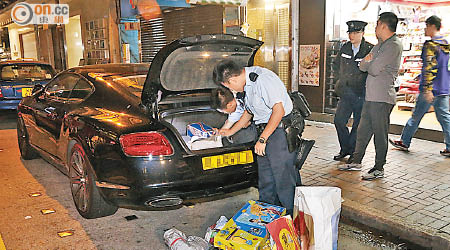 警員取出賓利跑車車尾箱內雜物搜查。（林耀康攝）