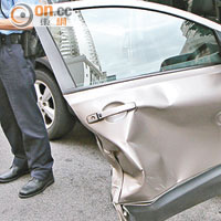 日產私家車的右車門被撞毀，司機一臉無奈（左）。