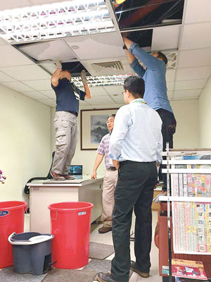 工作人員檢查航警局發證台辦公室出現漏水的天花板。（中時電子報圖片）