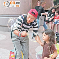蘇春就在街頭表演雜耍之餘，亦不忘與小朋友互動。