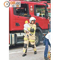 消防員抱起受傷男嬰。（讀者提供）