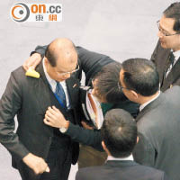 社民連代表在公聽會後圍追張建宗（左），將「不孝」貼紙貼在他上衣，批評政府愧對長者。