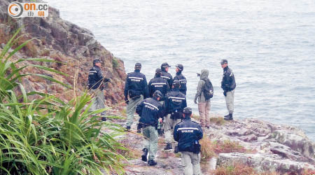 警員在海邊山崖搜尋。（吳欽旺攝）