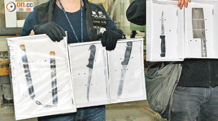 警方展示檢獲的刀和雙節棍等武器。