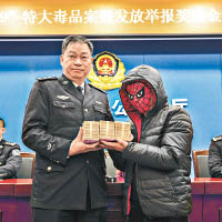廣東省公安廳禁毒局局長鄧建偉（左）向舉報者頒發獎金。（中新社圖片）