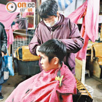 經營廿多年的理髮店昨晚仍然開舖，熟客專程來捧場。（黃雄攝）