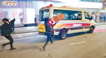 暴徒追擊警車掟垃圾桶。（楊日權攝）