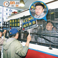 另一被告「美國隊長」容偉業（圓圖）昨早被警車押送到庭時，遭保衞香港運動成員指罵。