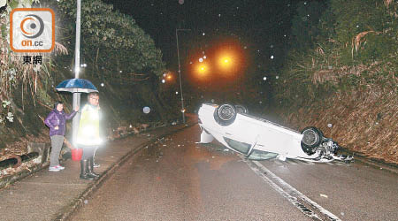 肇事跑房車撞山坡後「反肚」橫亘路中。（賴南秋攝）