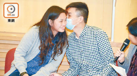 成功換心的陳英傑（右）昨親吻愛妻，並感激捐心者令他與妻兒團圓。（蕭毅攝）