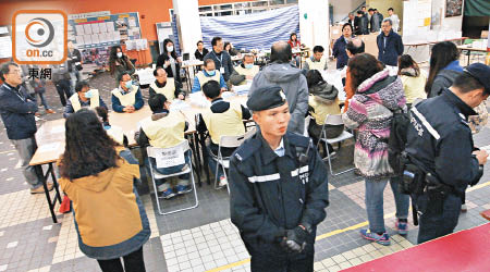 馬鞍山陳震夏中學票站因爆出「失匙爆箱」鬧劇，點票時要有警員駐守。（蕭偉健攝）