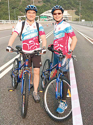 邱誠武（左）同梁敬國參加單車比賽活動，仲喺南灣隧道前留影。（互聯網）