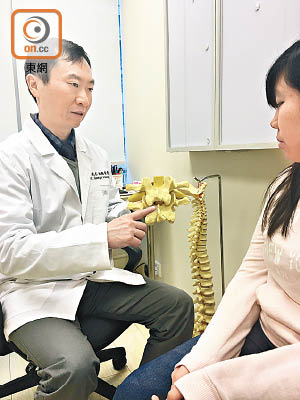 黃先志（左）向患者講解頸椎錯位成因。