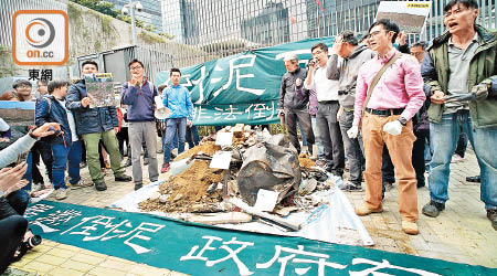 示威者帶同逾百包泥頭及建築廢料到政府總部前傾倒，堆成一座小泥頭山。（洪業銘攝）