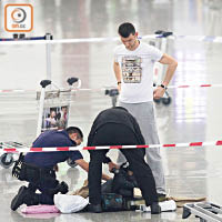 警方在涉事阿爾巴尼亞男遊客面前打開行李篋檢查。（文健雄攝）