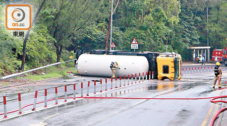 長沙灣<br>氣缸車翻側橫亘路中，消防員在場檢查。（馮裕亨攝）