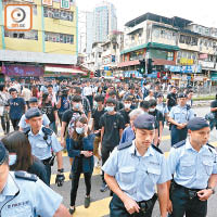 警員護送一批學生團體代表離開遊行現場。