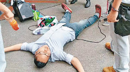 「快必」譚得志於街站遭人搶咪被推跌倒地。（互聯網圖片）