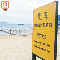 泳灘警告牌提醒泳客勿游近防鯊網。