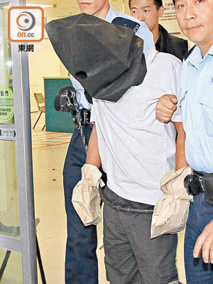 被告曾文緯被警方拘捕後，雙手要包上手套押走。