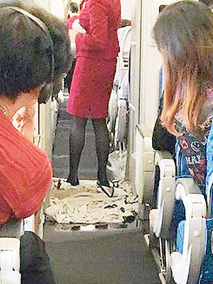 空姐用腳踏毛巾吸去由廁所漏出的污水。（互聯網圖片）