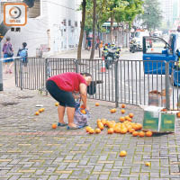街坊彎腰笑着執橙。