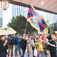 有民陣示威者高舉黃傘及象徵藏獨的雪山獅子旗。（胡家豪攝）