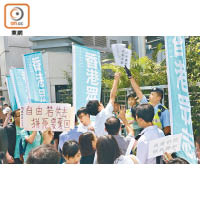 香港眾志成員企圖將示威物品擲入中聯辦內，但被警員阻止。