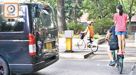 上水<br>有幼童雙腳站在單車尾架上，騎車者猶如表演雜技般駛過馬路。